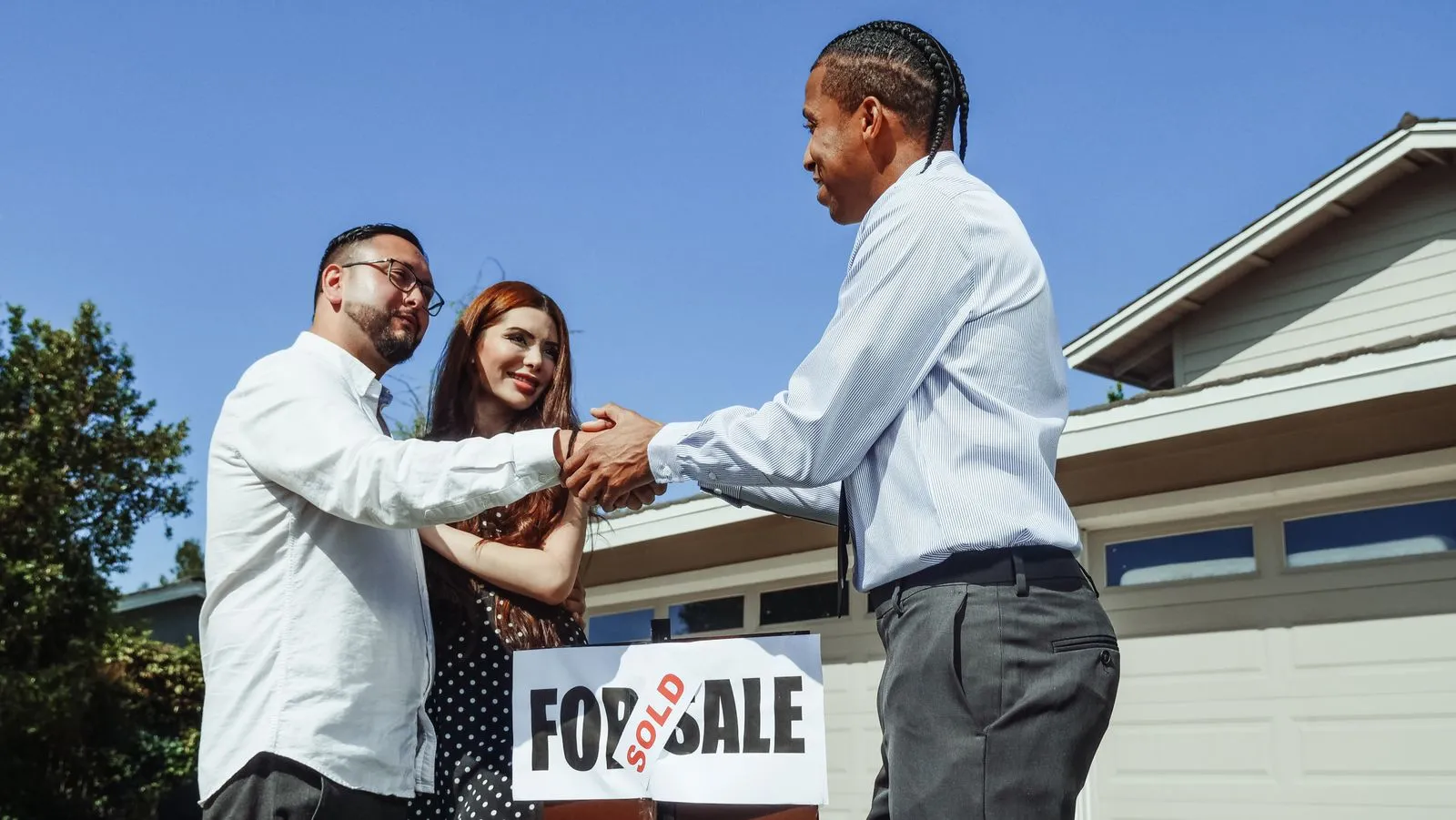 Poignée de main entre acheteur et vendeur au-dessus d'un compromis de vente immobilier